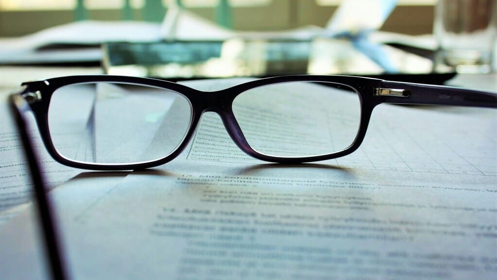 gafas negras reposan sobre un documento de herencias, insolvencia y derecho urbanístico